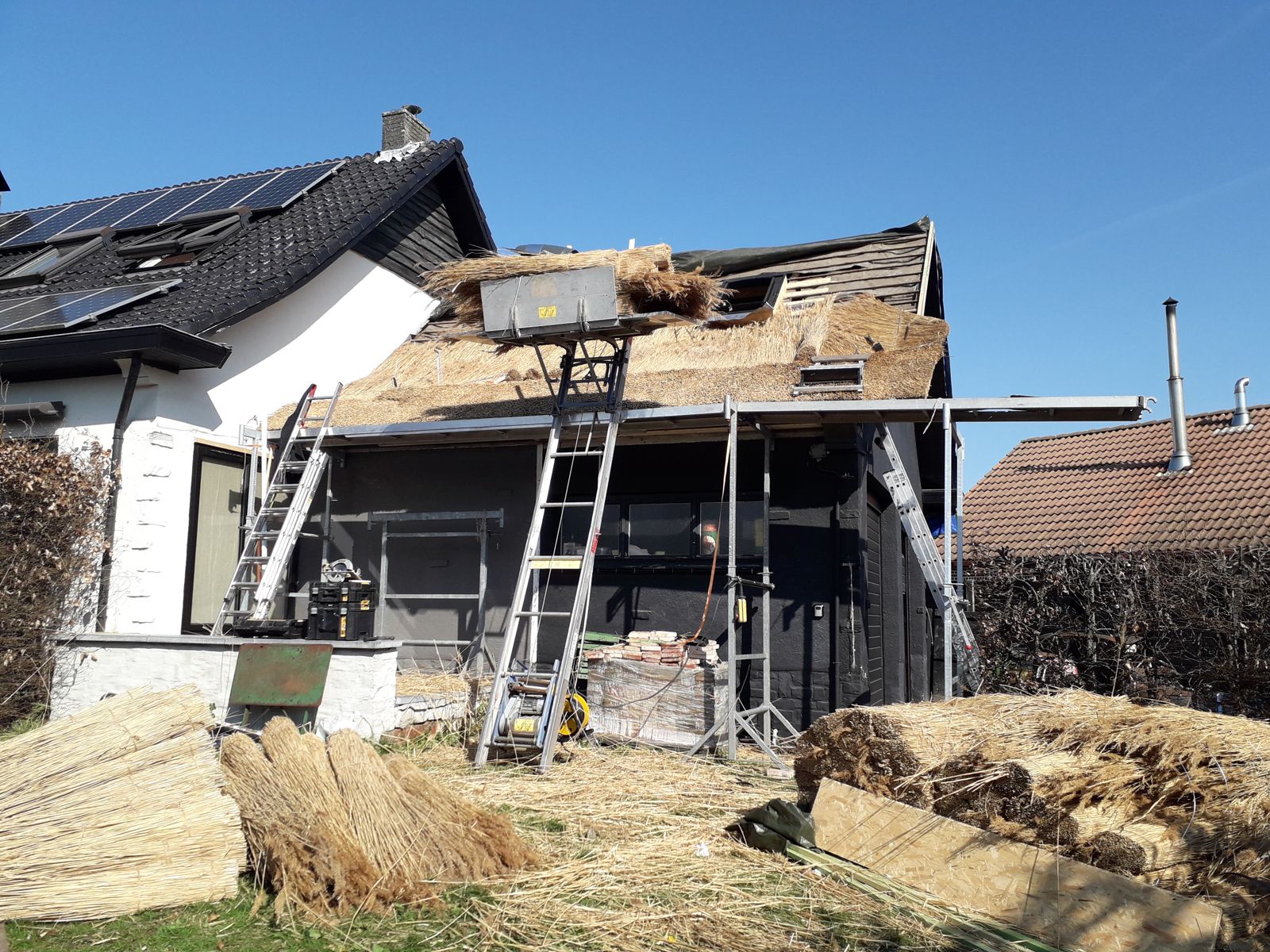 Rietwerk in uitvoering met bundels riet klaar op de werf
