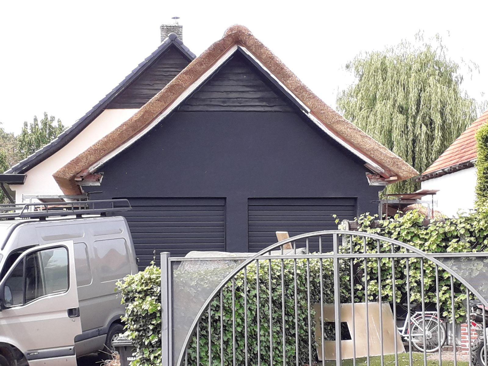 Woning met rieten dak en donkere gevelbekleding